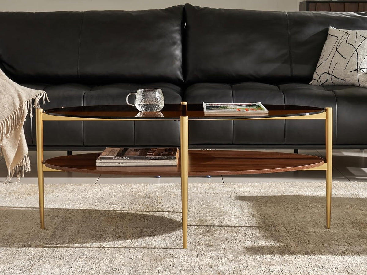 Shrine Oval Coffee Table, Mid-Century Modern Design, 2-Tier Structure, Amber Glass Top and Walnut MDF Shelf, 47" D x 21" W x 17" H, Sleek Conical Metal Legs with Gold Finish